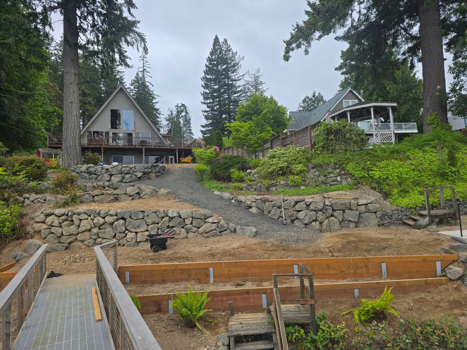 Multi-level retaining wall and slope landscaping under construction near residential homes in the Puget Sound region